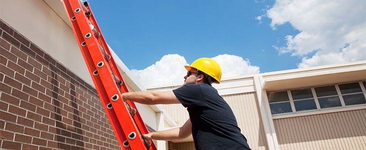 workman using red double extension ladders